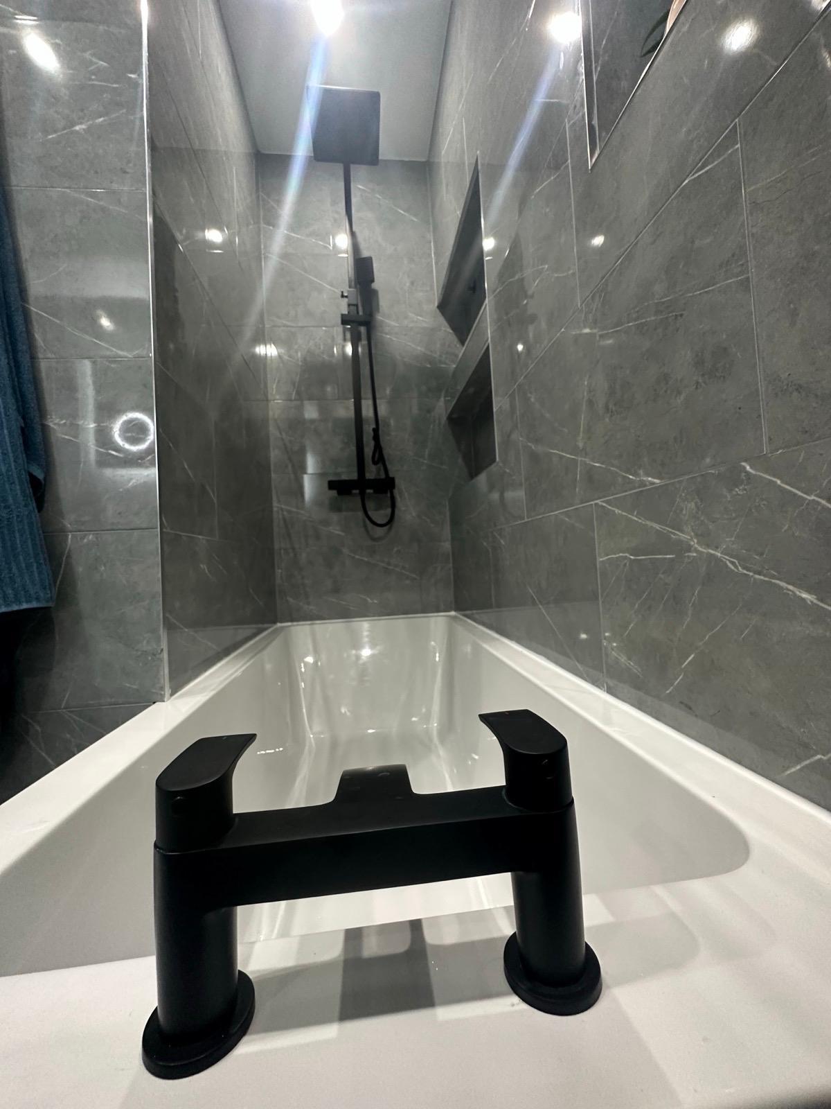 Plumber taking a service call while working under a sink
